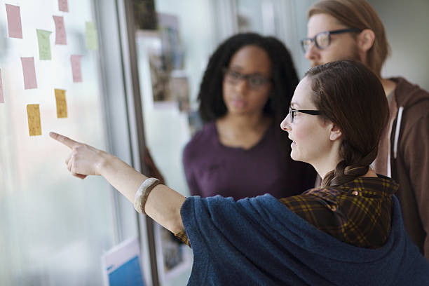 creative colleagues reviewing ideas on wall in studio office